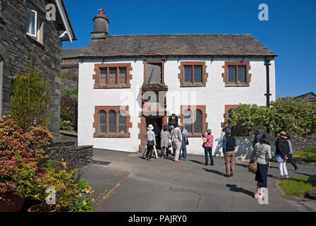 Touristen Besucher außerhalb des Old Grammar School Museum (früher von William Wordsworth besucht) Hawkshead Cumbria England Großbritannien Stockfoto