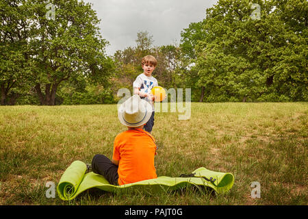 Zwei süße kleine Kinder, zusammen zu spielen, im Sommer. Kinder spielen mit Ball im Freien Stockfoto