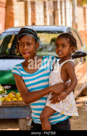 BANJUL, Gambia - Mar 14, 2013: Unbekannter gambischen Frau und ihr kleines Baby auf dem Markt in Gambia, Mar 14, 2013. Menschen in Gambia Leiden von povert Stockfoto