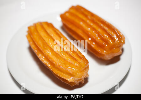 Türkische tulumba Dessert auf weiße Platte, Nahaufnahme Stockfoto