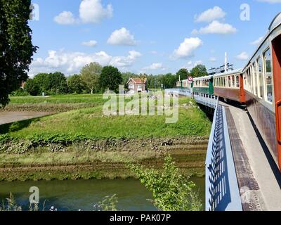 Le Chemin de Fer, Baie de Somme, Zug mit Dampflokomotive, überqueren eine Brücke, wie es fährt Saint-Valery-sur-Somme, Frankreich. Stockfoto