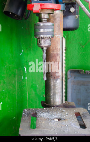 Heavy Duty Industrial Bohrer mit Metallteilen überall ein Schmutziger grüner Hintergrund Stockfoto