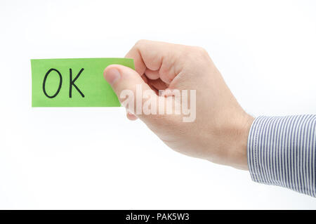 OK Genehmigung Konzept durch eine grüne Karte in der Hand eines Business Mann auf einem weißen Hintergrund vorgeschlagen Stockfoto