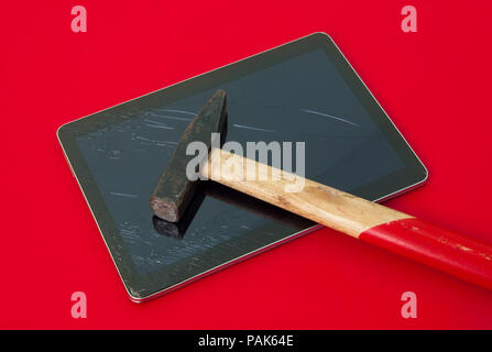 Mit einem Hammer auf eine defekte Touchscreen Tablet auf einem roten wichtig gefährliche ernsten Hintergrund schlägt nicht ein Unfall und Glas alarmiert ersetzen Stockfoto