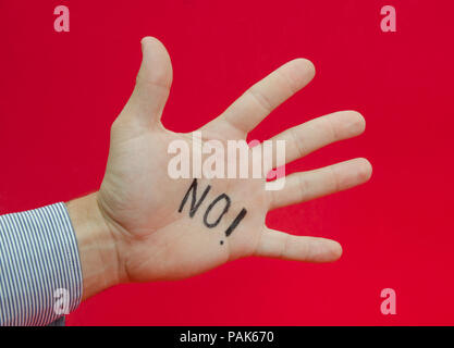 Sprechen Sie mit der Hand oder Nein sagen zu etwas von der Hand eines Business Mann schlug ohne Writen auf es auf einem roten Hintergrund alarmiert Stockfoto