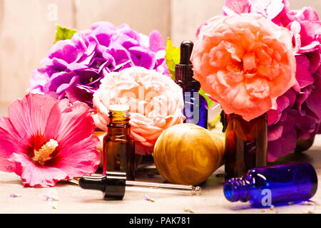 Blumen und Flaschen mit ätherischen Ölen für die Aromatherapie Stockfoto