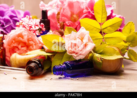 Blumen und Flaschen mit ätherischen Ölen für die Aromatherapie Stockfoto