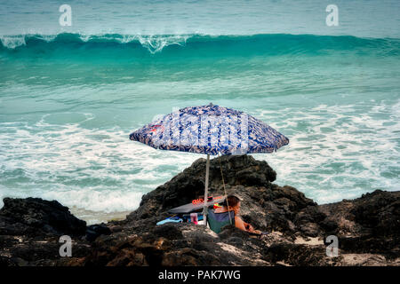 Mann unter dem Dach und Wellen. Kua Bay, Hawaii, Big Island. Stockfoto
