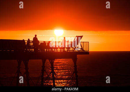 Aberystwyth Wales UK, Montag, 23. Juli 2018 UK Wetter: Menschen, die von den herrlichen Sonnenuntergang über Aberystwyth Pier Silhouette am Ende der heißesten Tag des Sommers so weit, mit Temperaturen Hoechststand von 33,3°C im Santon Downham, Suffolk. Großbritannien große Hitzewelle fort, ohne Atempause von der sehr trockenen Wetter, und das Met Office hat ein 'Wärme Health Watch Alert für viel der Osten und Südosten Englands Photo Credit: Keith Morris/Alamy Live Neuigkeiten Stockfoto