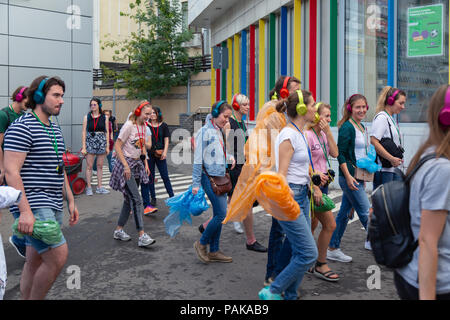 Moskau, Russland. 22. Juli 2018. Eine Gruppe junger Leute in identischen mehrfarbige Kopfhörer SONY'h. Ohr auf" für die Partei in der Nähe der Eingang zur U-Bahn-Station Savelovskaya. Nach ein paar Minuten begannen die Zuhörer zu begrüßen und mit einem Lächeln auf ihren Gesichtern schnell in der Masse der Fahrgäste gelöst. Remote Moskau ist eine Leistung - Reise quer durch Moskau für eine Gruppe von 50 Personen. Dies ist ein Theater Projekt einer neuen Format im Genre der 'Promenade - Leistung', verbindet Elemente einer Performance, eine Exkursion, ein Computerspiel und ein Abenteuer. Credit: Andrey Yanevich/Alamy leben Nachrichten Stockfoto