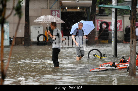 (180724) - Tianjin, 24. Juli 2018 (Xinhua) - Fußgänger gehen auf eine überflutete Straße in Nankai Stadtteil North China Tianjin Gemeinde, 24. Juli 2018. Schwere Unwetter von Typhoon Ampil schlug Peking und benachbarten Gebieten zwischen Montag und Dienstag Morgen, den Nationalen Meteorologischen Center (NMC) sagte. (Xinhua/Li Ran) (hxy) Stockfoto