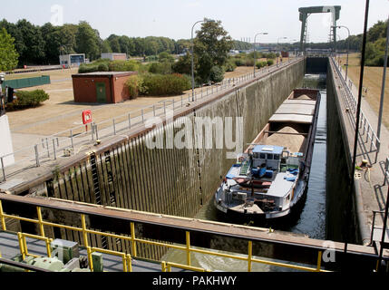 Friedrichsfeld, Deutschland. 24. Juli, 2018. Ein Frachtschiff steht in der friedrichsfeld Lock in der Nähe von Wesel. Die Dämme der Wesel-Datteln-Kanal kurz vor der Mündung in den Rhein. Aufgrund der fragilen Poller auf dem Schloss Wänden, es gibt lange Wartezeiten an den Schleusen. Foto: Roland Weihrauch/dpa/Alamy leben Nachrichten Stockfoto