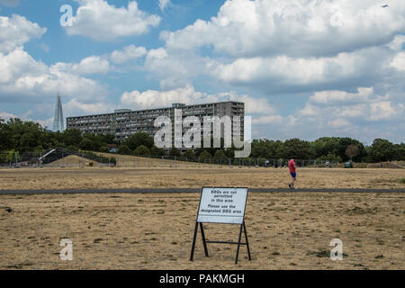 London, Großbritannien. 24. Juli, 2018. London erhält eine Atempause mit einigen Cloud, aber immer noch kein Regen im Süden Londons, wo das Gras in Burgess Park mehr wie Sand mit dem Wendover Block des Aylesbury Immobilien sieht im Hintergrund mit dem Shard ausgetrocknet. David Rowe/Alamy Leben Nachrichten. Stockfoto