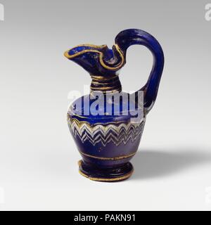 Glas oinochoe (Parfüm Kanne). Kultur: Griechisch, östlichen Mittelmeer. Abmessungen: H.: 2 1/2 in. (6,4 cm). Datum: 4.-3.Jh. v. Chr.. Transluzente Kobaltblau, mit Griff in der gleichen Farbe; Wanderwege in opak Gelb und Deckweiß. Angewandte großen Kleeblatt rim-disk; kurz zylindrischen Hals, verjüngt sich nach oben; breite abgerundete Schulter; Stright-seitig Körper mit ausgeprägten Abwärtstrend Konus; angewandte Niedrige kreisförmige Spiralkabel pad-base, mit abgeflachten Boden; Strap Griff an Schulter, ausgearbeitet und Runden in einer Kurve, Brückenbildung über der RIM-Disk, und drückte auf der Hals hinter Rim nach oben-Disk. Eine gelbe trail Atta Stockfoto