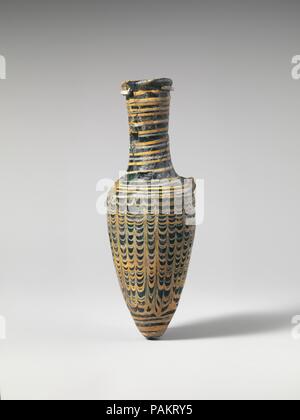 Glas amphoriskos (Parfüm Flasche). Kultur: griechisch-zypriotischen. Abmessungen: Insgesamt: 5 5/8 x 1 15/16 in. (14,3 x 4,9 cm). Datum: 1. Jahrhundert v. Chr.. Durchscheinende Licht blau; opak gelben und weißen Spur; Griffe und Knopf Base in transluzent gelb-grün. Nach innen geneigte Rim-disk; dickwandige Hals, verjüngt sich leicht nach unten, dann Ausbau schräge Schulter; länglich eiförmig, spitz zulaufend, auf Unterseite, mit der angewandten Knopf Base; zwei Riemen Griffe angewendet zu Schultern und oberen Teil des Halses. Wanderwege bei Rim beantragt, in einer Spirale um den Hals, über die Schulter, um Körper und Trail Stockfoto