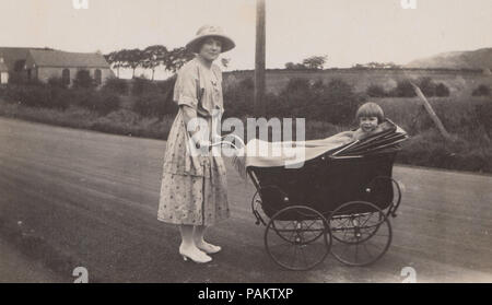 Vintage Foto einer Dame Drücken ein Kind im Kinderwagen Stockfoto