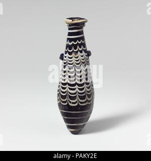 Glas alabastron (Parfüm Flasche). Kultur: Griechisch, östlichen Mittelmeer. Abmessungen: Höhe: 4 13/16-in. (12,2 cm) Durchmesser: 1 1/2 x 7/8 in. (3,8 × 2,3 cm). Datum: 2. bis Mitte 1. Jahrhundert v. Chr.. Transluzente Kobaltblau, mit Griffen in der gleichen Farbe; Wanderwege in opak weiß. Rim-Disk mit dicken abgerundete Kante, uneben, mit strahlenden Schnittspuren auf Oberfläche und Projektierung gezackten inneren Rand in den Mund; Gerade-seitig fusiform Körper nach unten erweitert, dann verjüngt sich wies unten; zwei horizontalen Stift griffen über Trail auf der Oberseite des Körpers angewandt, eine etwas höher als die anderen. Dicke trail Appl Stockfoto