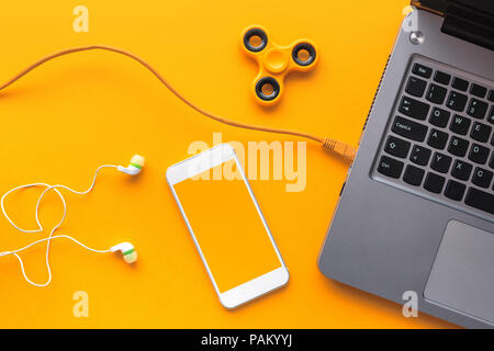 Gadgets, die junge Person - Laptop und Smartphone mit Kopfhörern und zappeln Spinner in der Ansicht von oben flach Stil Stockfoto