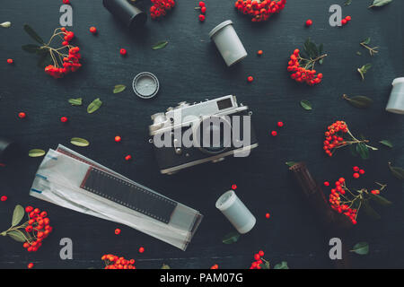 Flach hipster style Old vintage Fotografie Kamera auf dunklem Hintergrund mit Blumenschmuck Stockfoto