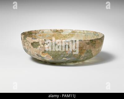 Glasschale. Kultur: Roman. Abmessungen: Insgesamt: 1 9/16-in. (3.9Cm) Durchm.: 4 7/8 in. (12,4 cm). Datum: Ende 1.Jh. v. Chr. - frühe 1. Jh. N.CHR.. Transluzente sehr blass blau grün. Vertikale, abgerundete Kante; konvexen oberen Seiten, dann drehte er sich in einen Winkel und unten geschwungenen zu flachen Boden. Rad-cut Dekoration auf innere, bestehend aus einem breite horizontale Nut unter Rim und zwei parallele, schmalere Linien im Winkel in Seiten. Intakt, aber interne Risse und leichte Kerben in Rim; wenige Blasen; tiefe Rillen, brillante Schillern und milchig-weiße Verwitterung. Museum: Metropolitan Museum of Art, New York, Stockfoto