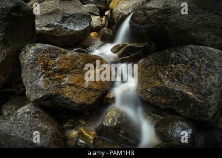 Kleine Felsbrocken und weich fließende Wasser im Bach an der Basis der Bridalveil Falls - eine touristische Destination auf Wawona Road - Yosemite National Park Stockfoto