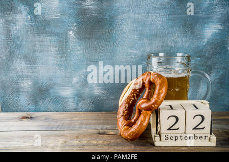 Oktoberfest Konzept mit Bier Glas mug, Brezel und Alten im Retrostil auf Holz- Kalender-, Blau- und Holz- Hintergrund, kopieren Raum Stockfoto