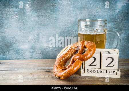 Oktoberfest Konzept mit Bier Glas mug, Brezel und Alten im Retrostil auf Holz- Kalender-, Blau- und Holz- Hintergrund, kopieren Raum Stockfoto