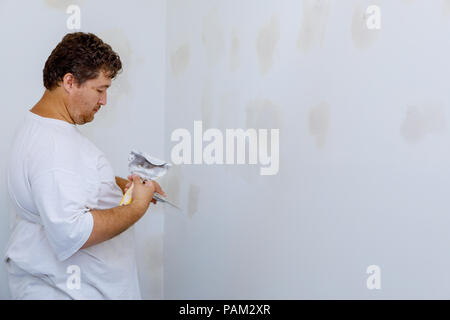 Arbeitnehmer richtet mit einem Spachtel Wand Stockfoto