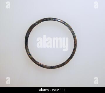 Glas Armband. Kultur: Roman. Abmessungen: Durchm.: 2 cm. (6,3 cm). Datum: Ca. 2.-4.Jh. N.CHR.. Transluzente Kobaltblau, erscheint schwarz. Kreisförmige Band; rechteckig in Abschnitt, mit abgerundeten Kanten; die Enden der Stange zusammen betätigt werden, eine über der anderen; leichte pontil Narbe auf der gegenüberliegenden Seite der Band. Intakt; Mattierung und irisierenden Verwitterung. Museum: Metropolitan Museum of Art, New York, USA. Stockfoto