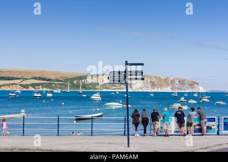 Menschen auf Swanage Promenade mit Blick aufs Meer auf einem warmen, sonnigen Sommern Tag während der Hitzewelle 2018, Dorset, Großbritannien Stockfoto