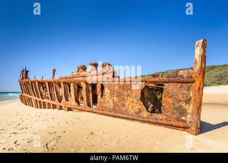 Die rosten Maheno schiffswrack am Strand auf Fraser Island, Queensland, Australien, fotografiert im hellen Sonnenlicht gegen einen klaren blauen Himmel Stockfoto