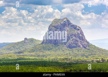 Mount Tibrogargan in die Glass House Mountains der Sunshine Coast, Queensland, Australien, fotografiert im hellen Sonnenschein vor einem blauen bewölkten Himmel Stockfoto