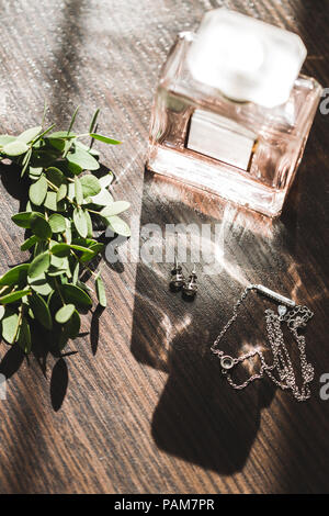 Die Braut Hochzeit Set Parfüm, Ohrringe, Halskette, Schmuck und grünen Kranz mit Bändern auf hölzernen Tisch Stockfoto