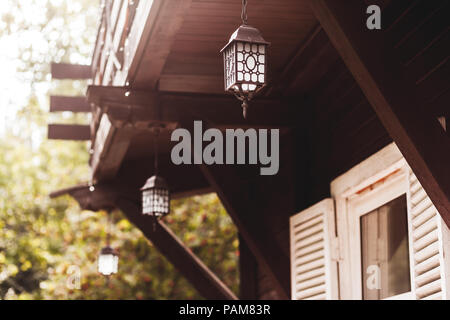Alte geschmiedete Laterne hängend auf der Terrasse des Hauses Stockfoto