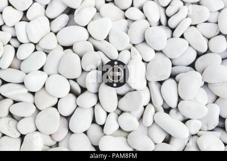 Trauringe in Runde schwarz auf weiß Pebble Stone Hintergrund Stockfoto