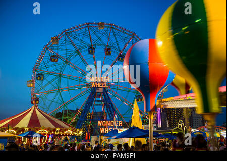 NEW YORK CITY - 20. AUGUST 2017: Die hellen Lichter der Wonder Wheel und Vergnügungspark auf Coney Island in Brooklyn Glühen vor Sommer Sonnenuntergang Himmel Stockfoto