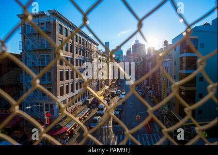 NEW YORK - ca. August 2017: Downtown Manhattan und Chinatown durch eine chainlink Fence auf der Manhattan Bridge gesehen. Stockfoto