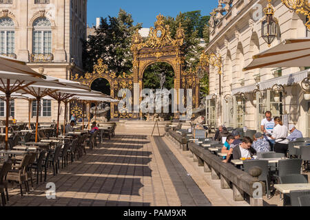Nancy, Frankreich, 22. Juni 2018: Café Terrasse in der Place Stanislas Platz und Nepture Springbrunnen im Hintergrund. Stockfoto