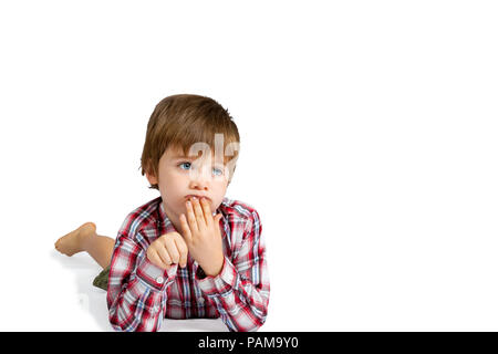 Ein Junge schaut tief in Gedanken, Verlegung auf seinen Magen mit seiner Hand an seine Lippen. Seine Fingernägel sind dreckig und er sieht verwirrt aus. Auf weiß Isoliert mit Stockfoto