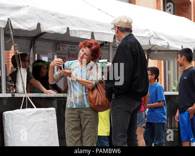 Ein älteres Paar mit Erfrischungen, einschließlich grüne Bier, am jährlichen St. Patrick's Day Block Festival in Corpus Christi, Texas USA. Stockfoto