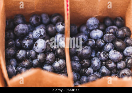 Frische Heidelbeeren in kleinen Handwerksbetrieben Papier Boxen auf Hochzeitsfeier Tabelle, rustikaler Stil, Sommer Stimmung Stockfoto