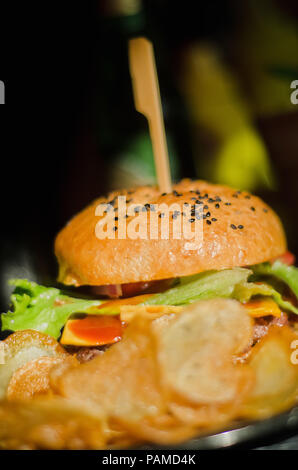 Nahaufnahme auf eine rustikale Hamburger mit schwarzem Sesam und Bränden vor Stockfoto
