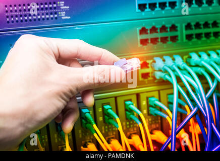 Hand stecken Kabel im Netzwerk Switch Stockfoto