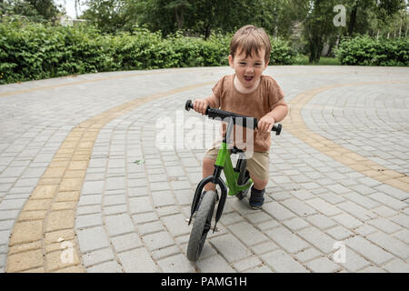 Happy Boy, ein kleines Fahrrad im Park Stockfoto