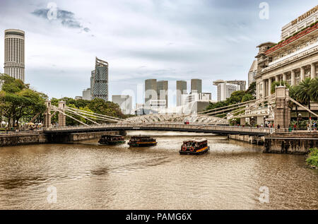 Singapur - Jan 14, 2018: River Tour Boote mit Touristen nähern sich historische suspension Cavenagh Brücke über den Fluss Singapur in Singapur. Stockfoto