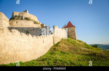 Mittelalterliche Festung in Rupea/Reps in Siebenbürgen Region Rumäniens mit Steinmauern, die auf einer Klippe mit einem natürlichen Ackerland Landschaft und ein blauer Himmel Stockfoto