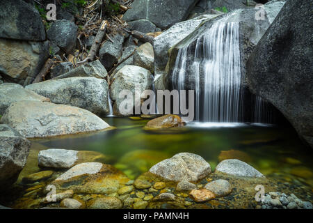 Faserig, fließende Cascade Creek Falls über gigantische Felsbrocken in einem natürlichen Pool-Highway 120 im Yosemite National Park Stockfoto