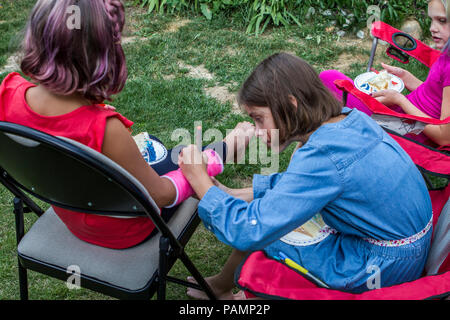 Süße Mädchen in blau oben, ssigning rosa Besetzung der Cousine Arm gebrochen. Links ist die Nr. 114, Rechts ist #113 Stockfoto