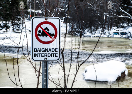 Baden verboten Schild vor einem teilweise gefroren, schnell fließenden Fluss Stockfoto