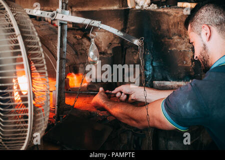 Einem jungen Glasbläser bläst ein Glas Schwan in einem Workshop in Hebron, Palästina Stockfoto